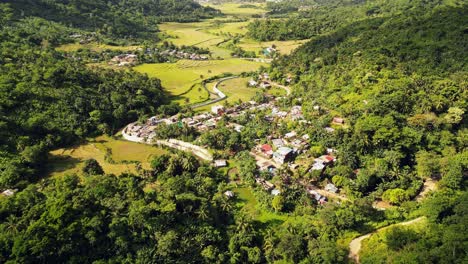 Small-philippine-settlement-in-rural-countryside-rain-forest,-aerial-forward