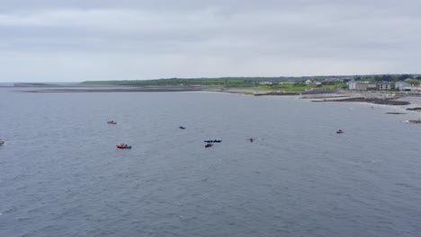 Drone-orbit-parallax-around-currach-boat-canoes-in-open-ocean-water-of-ireland