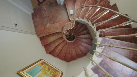 Slow-motion-rising-spiraling-shot-of-a-spiral-staircase-in-a-mansion-in-Montpellier