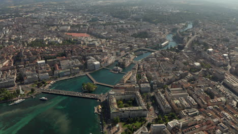 Aerial-shot-over-the-Rhone-river-passing-through-central-Geneva-on-a-sunny-day