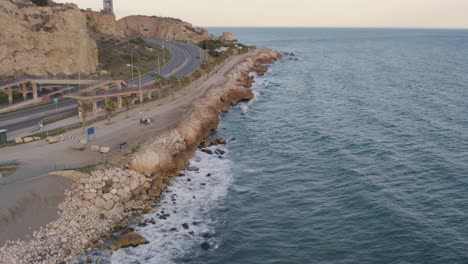 Aerial-view-over-rocky-shoreline-with-waves-splashing-in-Malaga,-Spain
