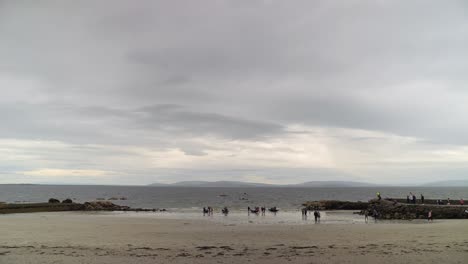 Wide-tilt-down-view-of-galway-bay-from-ladies-beach-ireland-as-currach-boats-race