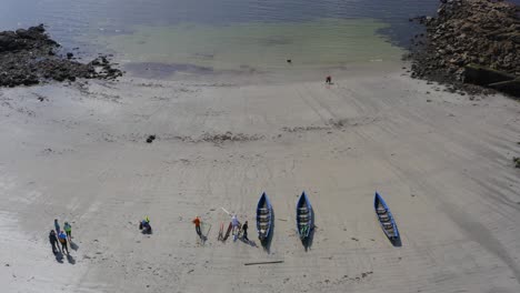 Drone-wide-view-of-currach-boats-being-loaded-with-oars-on-ladies-beach