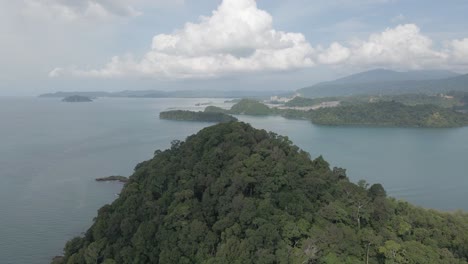 Jungle-mountain-islet-aerial-and-misty-ocean-scene,-good-speed-ramp