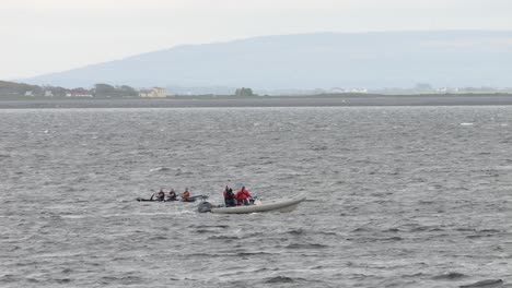 Support-safety-vessel-boat-watches-competitive-rowers-in-currach-boat