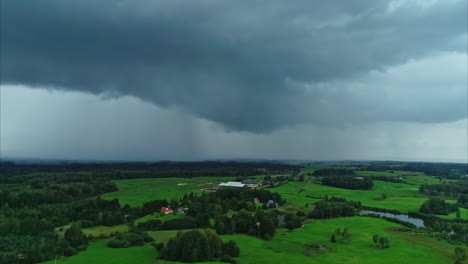 Timelapse--Static-wide-shot-of-clouds-and-rain-rolling-over-vast-green-landscape