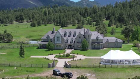 Aerial-view-of-mansion-and-outdoor-tent-for-wedding-celebration-at-Greystone-Castle,-Colorado,-United-States