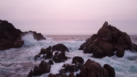 Rosa-Sonnenuntergangshimmel-Und-Felsige,-Zerklüftete-Küste,-Luftvorbeiflug-über-Dem-Meer