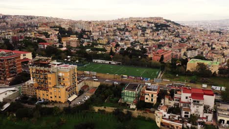 Aerial-drone-shot-of-Amateur-soccer-stadium-between-neighborhood-in-Naples-city---Beautiful-cityscape-with-crowded-residential-area-in-background