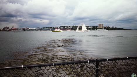 Sailboat-and-Casco-Bay-ferry-under-dark-clouds