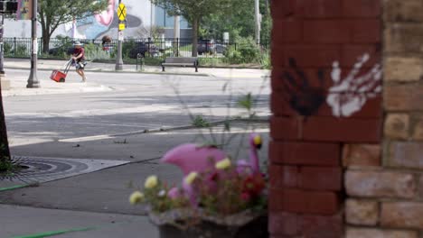 Flower-pot-and-hands-painting-in-Lansing,-Michigan-Old-Town-district-with-stable-establishing-shot-and-pull-focus
