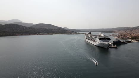 Aerial-flight-pass-huge-touristic-MSC-cruiseship-on-island-Kefalonia,-summer-day