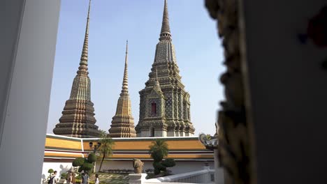 Slow-motion-shot-of-tourists-taking-photos-with-the-large-spires-in-The-Emerald-Buddha-Temple