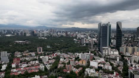 Aerial-hyperlapse-of-the-towers-of-Paseo-de-la-Reforma-and-surroundings-of-Chapultepec,-a-park-in-Mexico-City