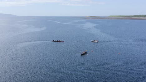 Drohne-Umkreist-Die-Meeresströmungen-In-Der-Bucht-Von-Galway,-Während-Sich-Currach-Ruderboote-Durch-Das-Wasser-Bewegen