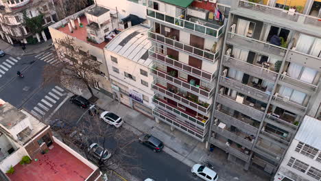Blick-Aus-Dem-Fenster-Des-Hauses-Auf-Die-Straße-In-Buenos-Aires,-Ein-Motorradfahrer-Fährt-An-Einer-Kreuzung-Vorbei,-Tag