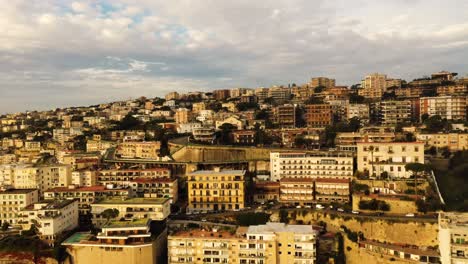Cinematic-drone-flight-showing-apartment-blocks-Lightning-by-sun-located-on-hill-of-Naples,Italy---Toward-flight
