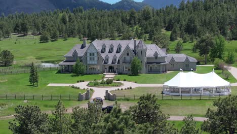 Huge-mansion-located-in-woodland,-mountain-background