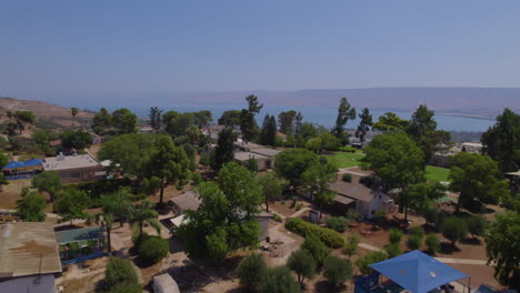 Push-in-reveal-the-Sea-of-Galilee-above-Kibbutz-Alomat-by-drone---a-cloudless-summer-day