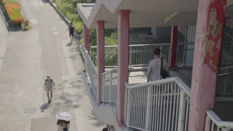 A-still-frame-immerses-viewers-in-the-tranquil-urban-setting-of-Hong-Kong,-as-pedestrians-are-observed-from-beneath-a-pedestrian-bridge-in-a-sparsely-populated-scene