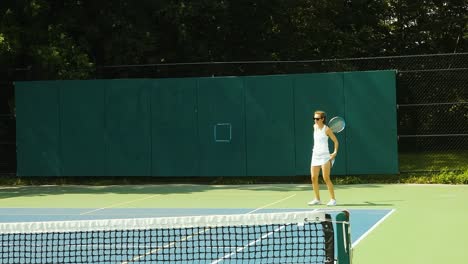 Young-woman-serves-in-tennis-match