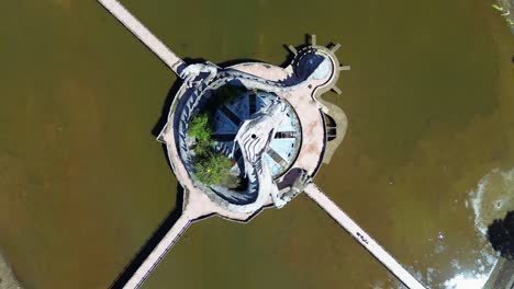Aerial-birds'-eye-top-down-ascending-view-of-Ho-Thuy-Tien-abandoned-water-park-with-a-huge-dragon-structure-and-empty-lake-in-Hue,-Vietnam