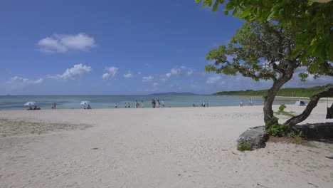 Captivating-time-lapse-captures-the-beauty-of-Kondoi-Beach-on-Taketomi-Island,-Okinawa,-Japan,-with-people-savoring-the-sunny-day