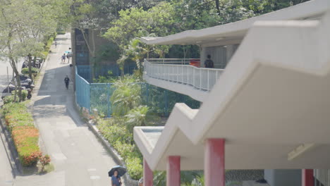 A-serene-urban-scene-unfolds-as-tiny-pedestrians-gracefully-move-under-a-bridge-in-Hong-Kong,-creating-a-tranquil-atmosphere