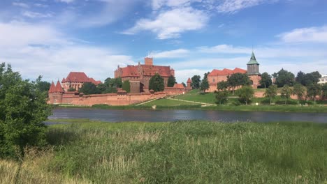 Panorama-of-Malbork-castle,-Poland-with-Nogat-river-in-front-of-it