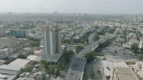 Aerial-drone-shot-from-right-to-left-of-traffic-movement-over-Shahrah-e-qaideen-road,-Karachi-Metropolitan-city-in-Pakistan-on-a-sunny-day