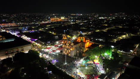 Aerial-view-away-from-the-illuminated-cathedral-at-the-San-Marcos-fair,-night-in-Aguascalientes,-Mexico