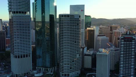 Establishing-aerial-shot,-slow-panning-capturing-riverside-downtown-cityscape-along-city-reach-boardwalk-at-Brisbane's-central-business-district-at-sunset-golden-hours