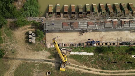 Aerial-drone-top-down-shot-flying-over-a-dam-under-repair-Dam-with-artificial-reservoir-visible-on-a-sunny-day