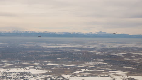 Two-planes-landing-at-Denver-International-airport-with-the-Rocky-Mountains-in-the-background