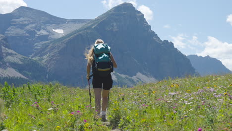 Solo-Caucasian-Hiker-Girl-Walking-on-Path-at-Cut-Bank,-Glacier-Park-on-a-Sunny,-Windy-Day