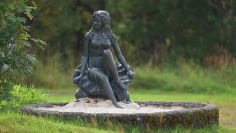 A-bronze-statue-of-a-young-woman-in-a-hotel-park