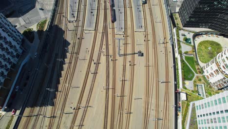 train-railroad-and-tracks-of-Vienna-central-station,-Aerial-overview,-wien-hauptbahnhof-flyover,-sunny-day-in-the-city-of-Vienna