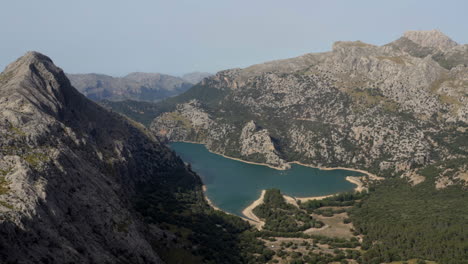 Mirador-des-Gorg-Blau-water-reservoir-in-valley-between-high-mountains