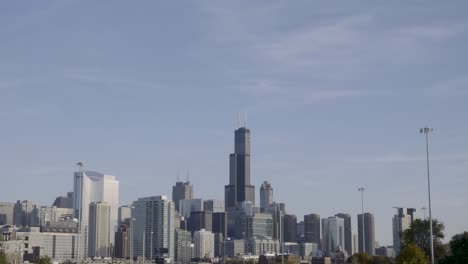 Skyline-Chicago-and-rush-hour-highway-with-cars,-tilt-down-establisher,-blue-sky
