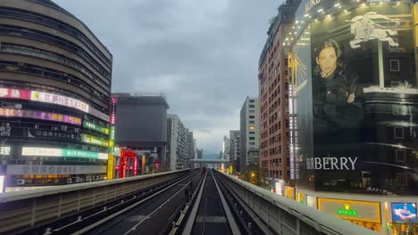 Front-view-of-Taipei-metro-driving-through-scenic-cityscape,-financial-buildings,-Zhongxiao-Dunhua-metro-station