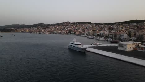 City-Argostoli,-Kefalonia,-Greece,-drone-backward-establisher-in-blue-hour,-ship