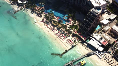 Luxurious-hotel-resort-with-parasols-and-swimming-pool-on-beach,-Cancun