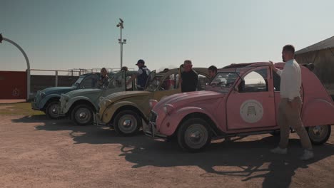 Dargestellt-Sind-Mehrere-Retro-Autos-In-Verschiedenen-Farben,-Aus-Denen-Alle-Fahrer-In-Einem-Einzigen-Moment-Gleichzeitig-Aussteigen