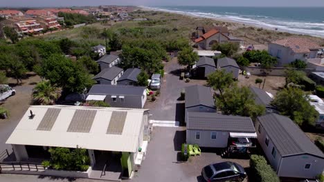 Vista-Aérea-De-Casas-Transformadas-En-Campamentos-Con-Vehículos-Recreativos-Estacionados-Cerca-De-La-Playa.
