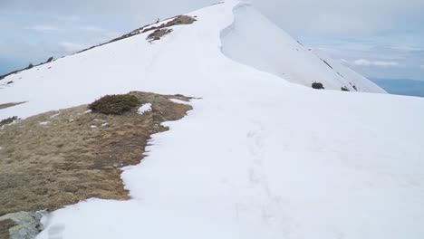 Parches-De-Hierba-Y-Roca-Se-Asoman-A-Través-De-La-Nieve-Cerca-Del-Pico-De-La-Montaña