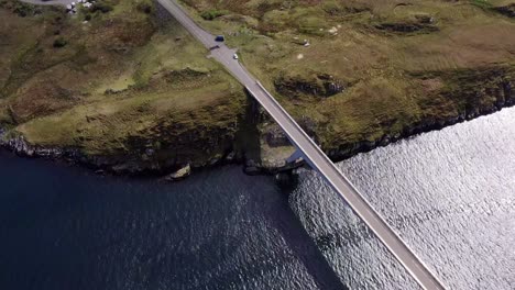 Dynamic-drone-shot-tilting-from-the-bridge-to-the-village-on-the-Isle-of-Scalpay,-an-island-near-the-Isles-of-Harris-and-Lewis-on-the-Outer-Hebrides-of-Scotland