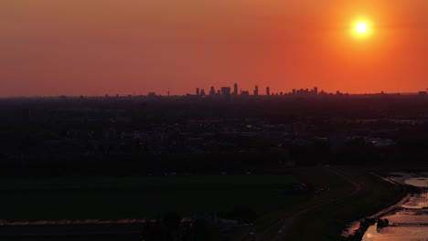 Sun-setting-with-dramatic-orange-skyline-over-Rotterdam,-Netherlands