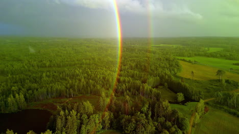 Aerial-view:-double-rainbow-graces-rural-forestry-landscape