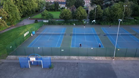 Gente-Jugando-Tenis-Al-Aire-Libre-En-Las-Canchas-Del-Parque-De-La-Ciudad-De-Londres,-Vista-Aérea