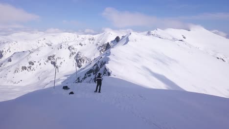 Mann-Steht-Allein-Auf-Dem-Gipfel-Des-Parang-Berges-Mit-Schneebedecktem-Landschaftshintergrund
